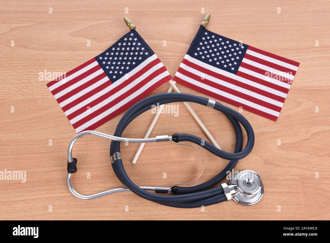 Concetto Di Assistenza Sanitaria Militare. Sfondo in legno chiaro con stetoscopio e due bandiere americane incrociate. Foto Stock