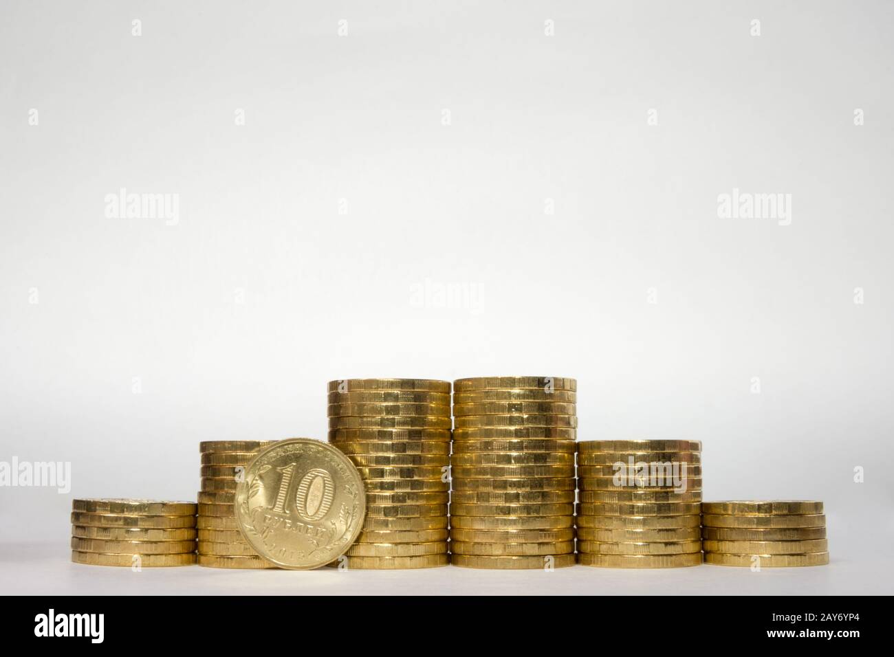Sei pile di monete che aumentano l'altezza simmetricamente su uno sfondo bianco, pockmarked sta sul bordo del rublo russo 10 Foto Stock