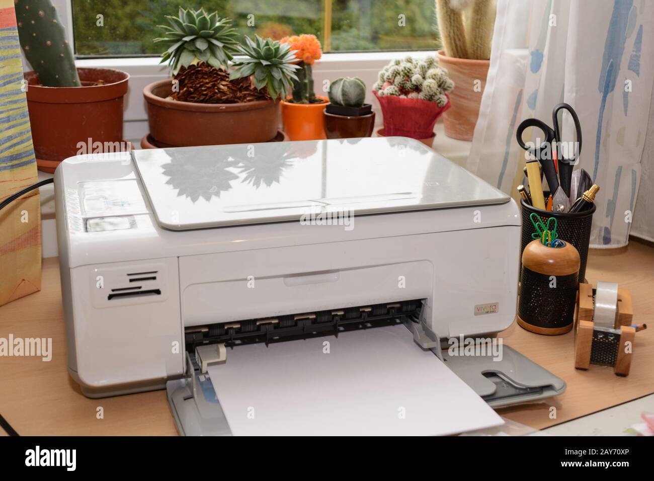 Le stampanti a getto d'inchiostro e altri accessori sono alla scrivania in un ufficio Foto Stock