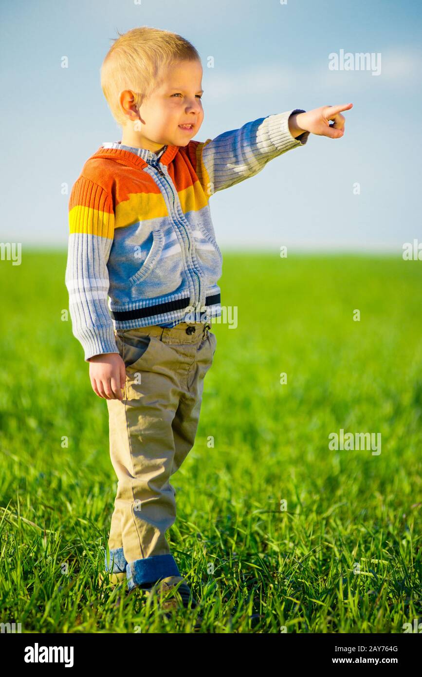 Ritratto di felice gioiosa bella little boy outdoor in campagna. Concetto di puntamento. Foto Stock