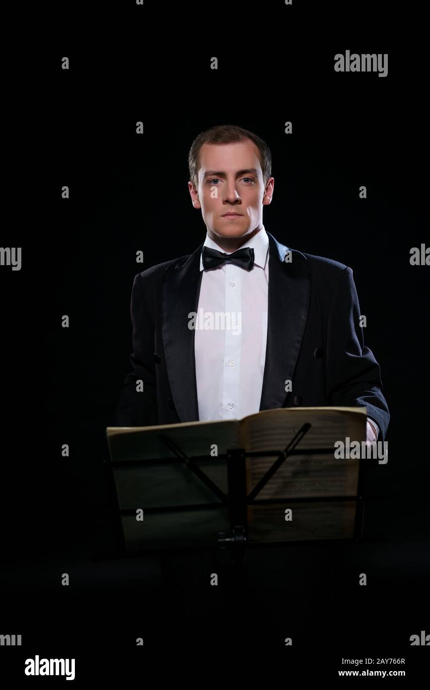 Orchestra in nero Tuxedo in dark studio Foto Stock