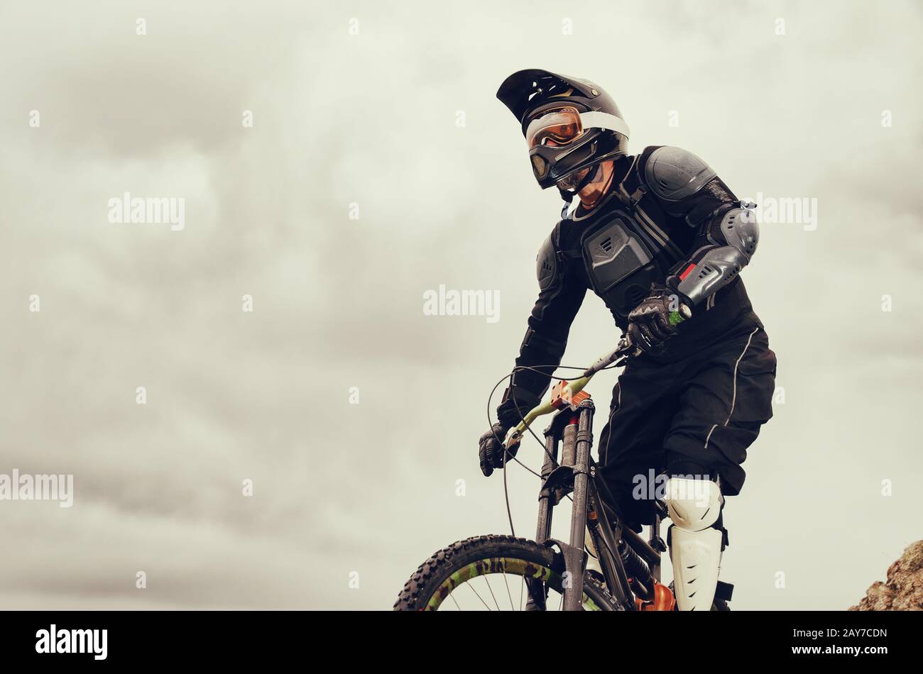 Discesa su una mountain bike in mountain bike passeggiate lungo la strada in natura sullo sfondo della catena montuosa o Foto Stock
