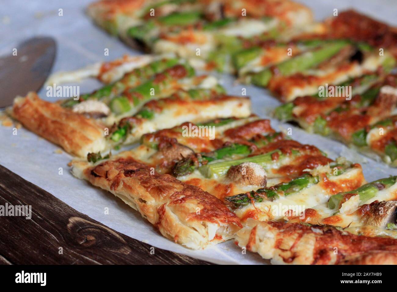 Pasta sfoglia con asparagi e formaggio. Uno spuntino delizioso e veloce con pasta sfoglia. Una cena perfetta e gustosa. Foto Stock