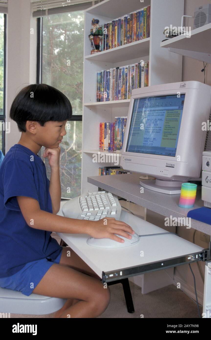 Austin, Texas: 7-year old Asian-American boy browses kid-friendly siti web. ©Bob Daemmrich Foto Stock