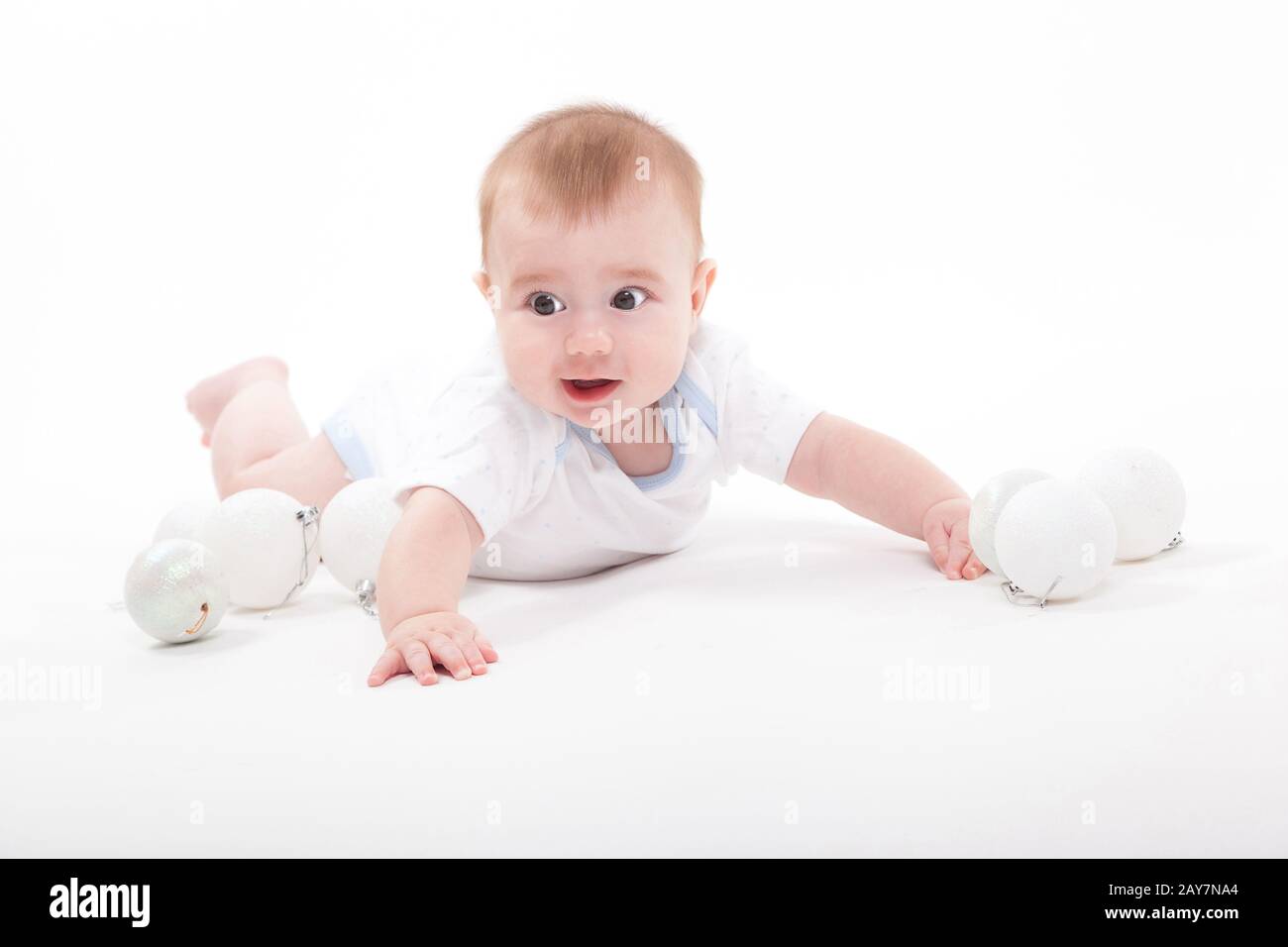 Bambino su uno sfondo bianco che gioca con i giocattoli di Natale Foto Stock