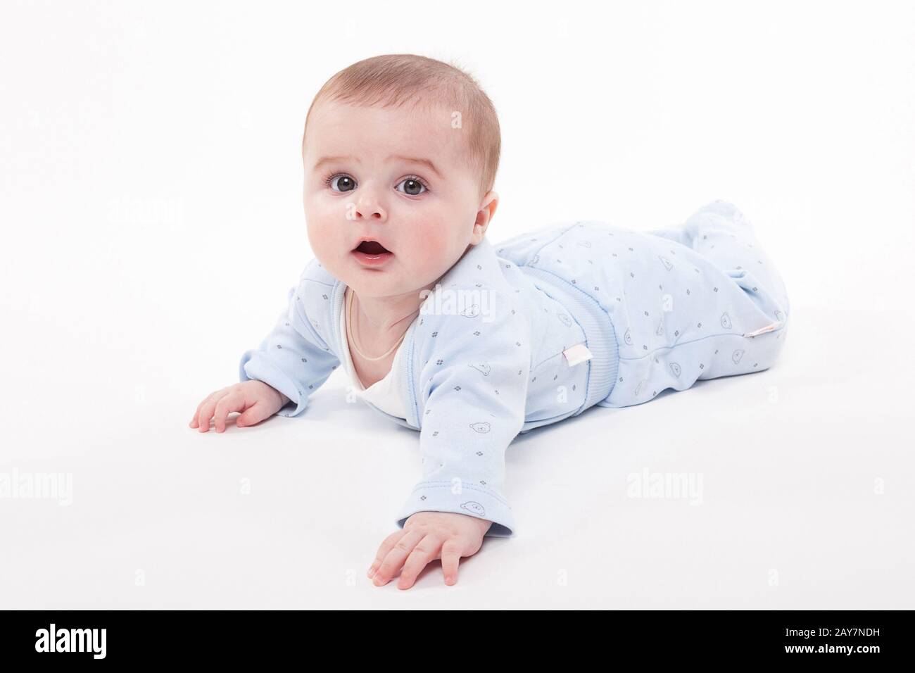 Il bambino nel corpo sdraiato sul suo stomaco su uno sfondo bianco e Foto Stock
