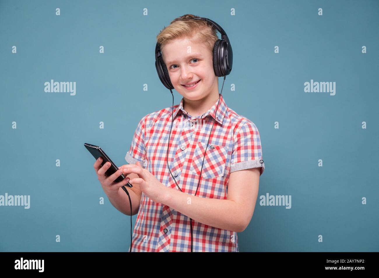 Studente con le cuffie guardando cellulare visualizzazione Foto Stock