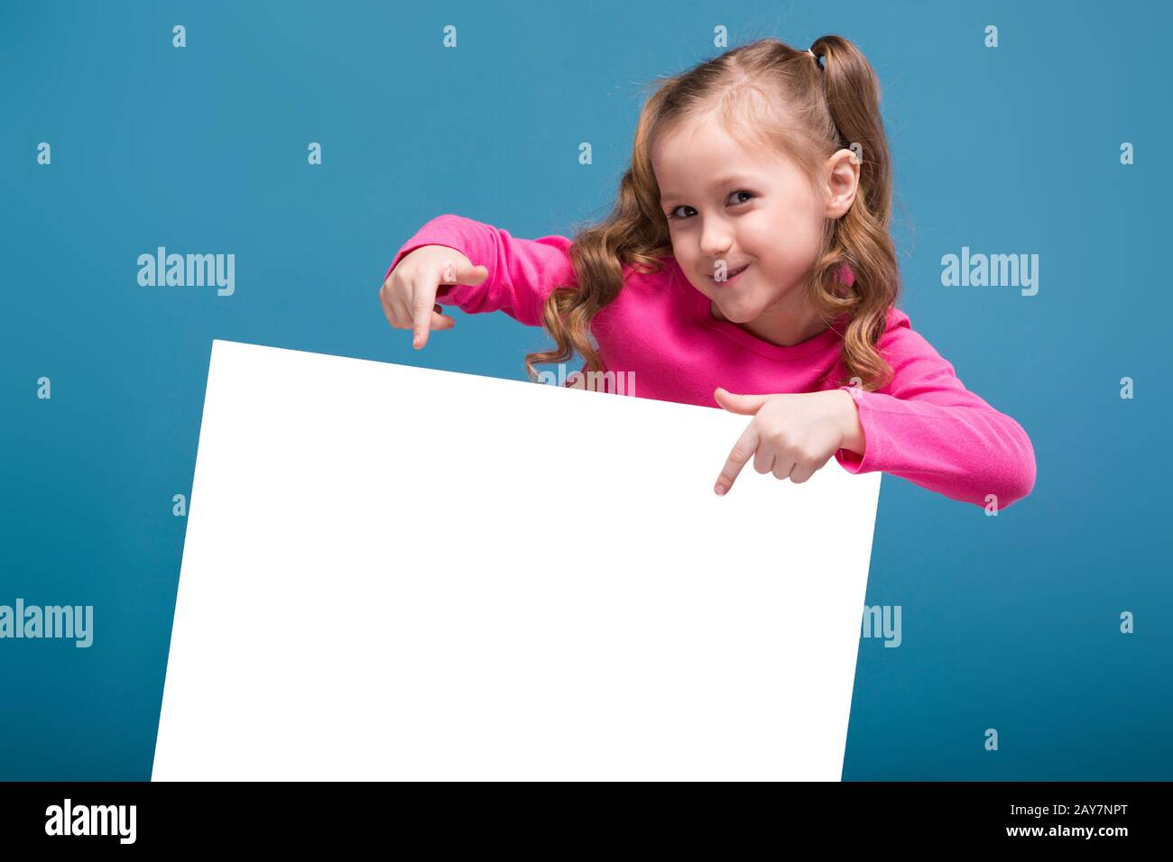 Attraente bambina carina in camicia rosa con scimmia e pantaloni blu tenere  poster vuoto Foto stock - Alamy