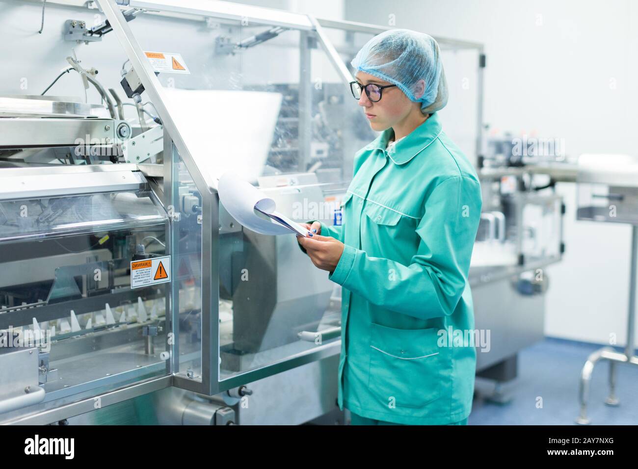 L'operatore controlla la macchina nel lavoro in fabbrica Foto Stock