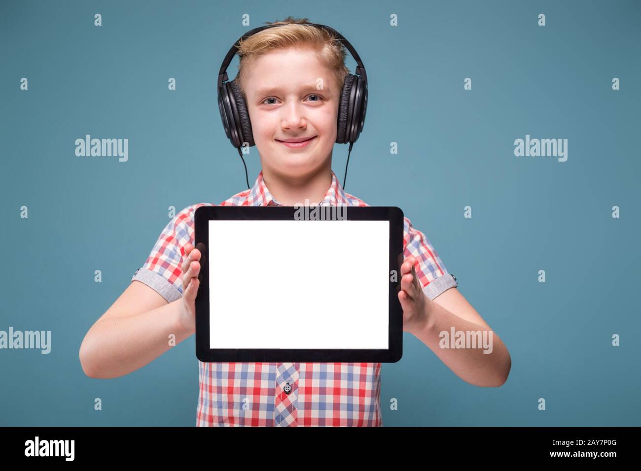 Teenager con cuffie mostra il display del tablet, foto con spazio per il testo Foto Stock