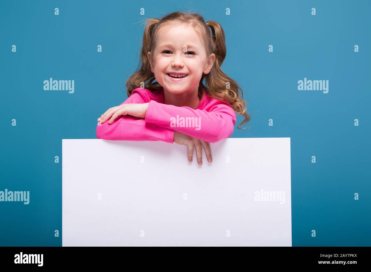 Attraente bambina carina in camicia rosa con scimmia e pantaloni blu tenere  poster vuoto Foto stock - Alamy