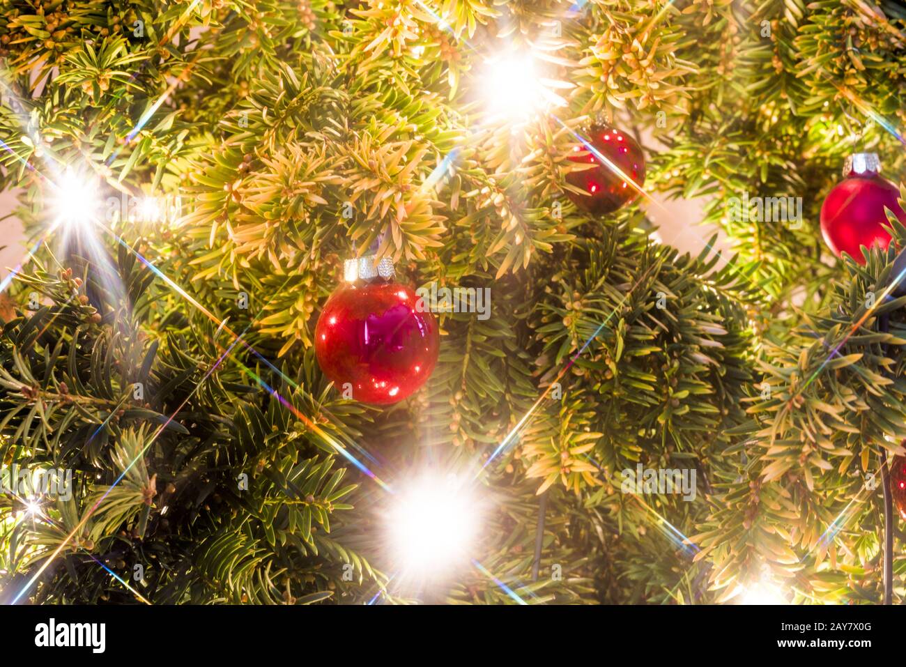 Primo piano di un albero di natale con luci e palline di natale come sfondo Foto Stock