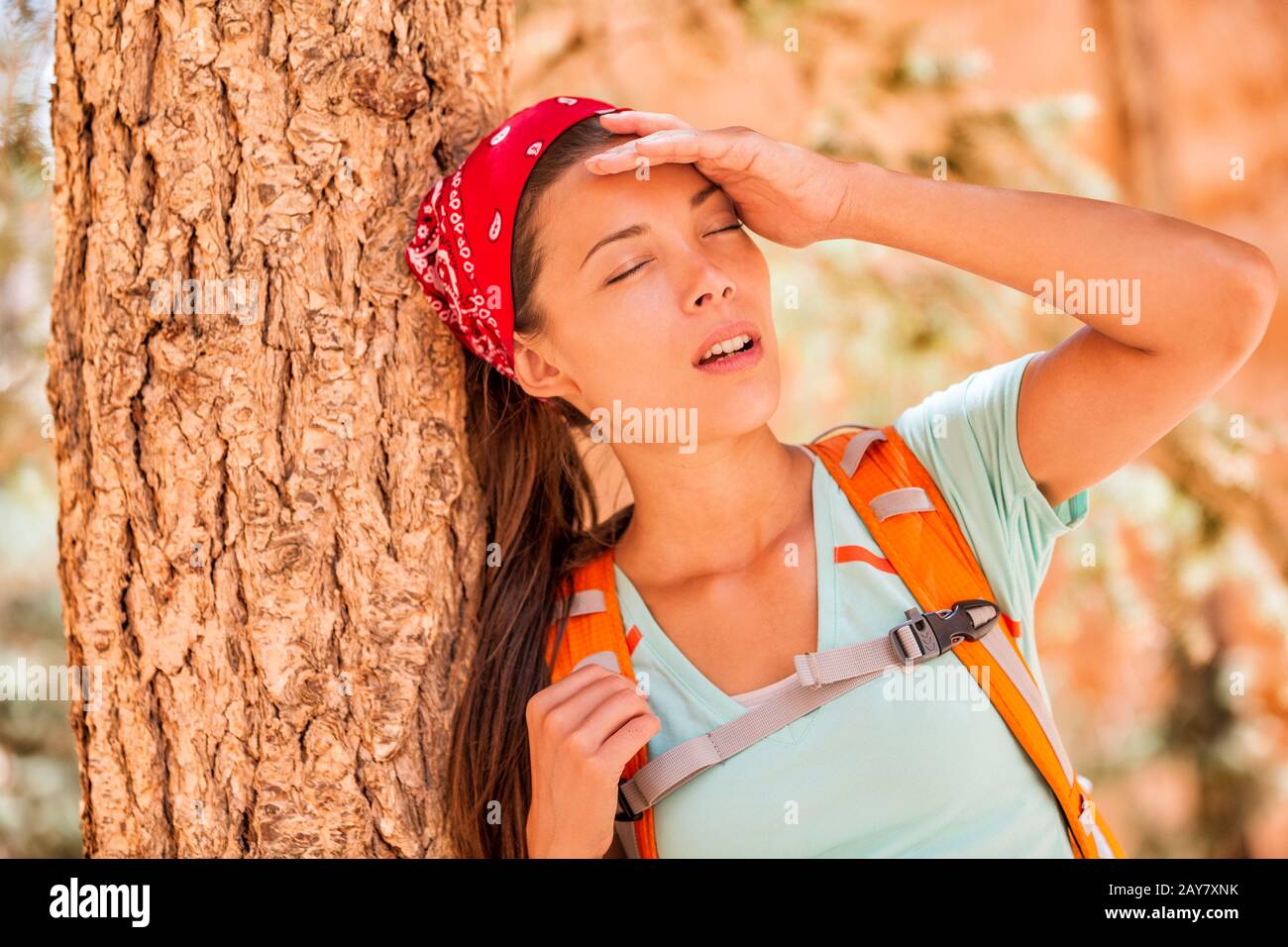 Disidratato stanco trekking donna sete sensazione di stanchezza colpo di calore. Ragazza con mal di testa da temperatura calda su attività all'aperto hiker lifestyle. Foto Stock