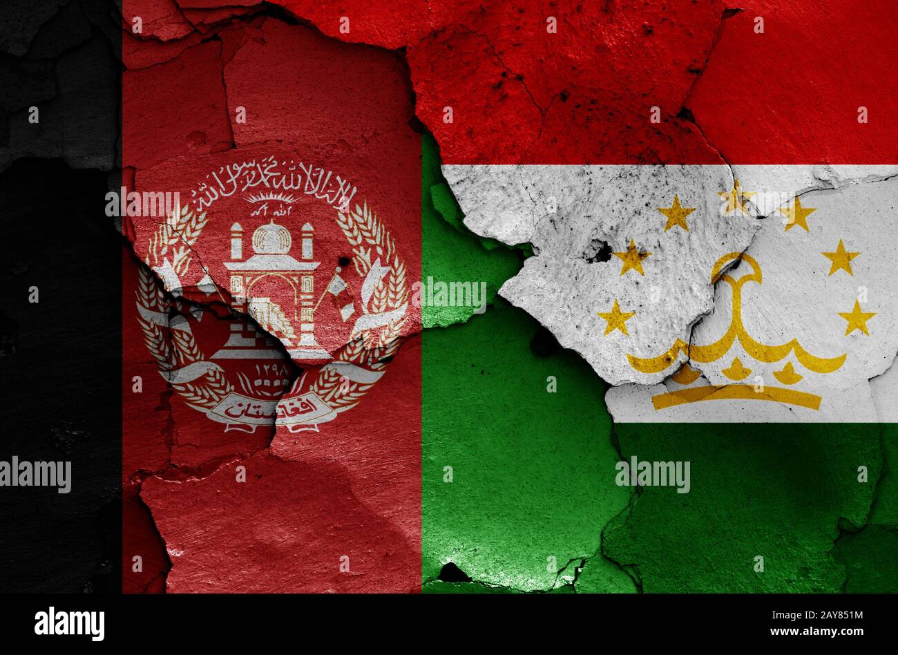 Bandiere dell'Afghanistan e del Tagikistan dipinte su pareti incrinate Foto Stock