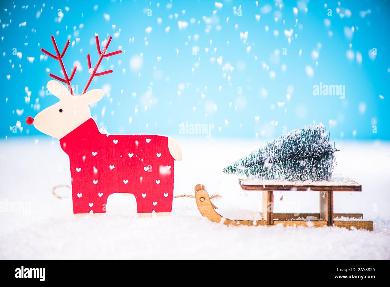 Le renne divertenti trasportano l'albero di Natale sulla slitta della neve Foto Stock