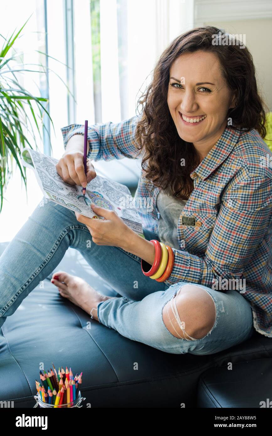 ragazza sorridente mentre lavora su hobby creativo di arte Foto Stock