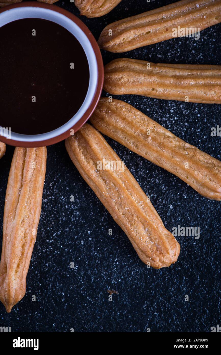 Churros fritto con un tuffo al cioccolato, sole messicano Foto Stock
