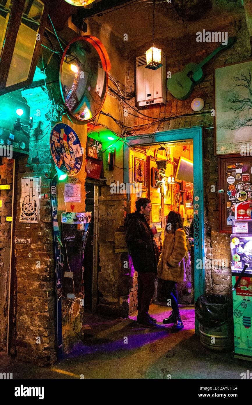 Una coppia parla all'interno di Szimpla Kert, il più antico bar in rovina all'interno di un'ex fabbrica abbandonata, Budapest, Ungheria Foto Stock