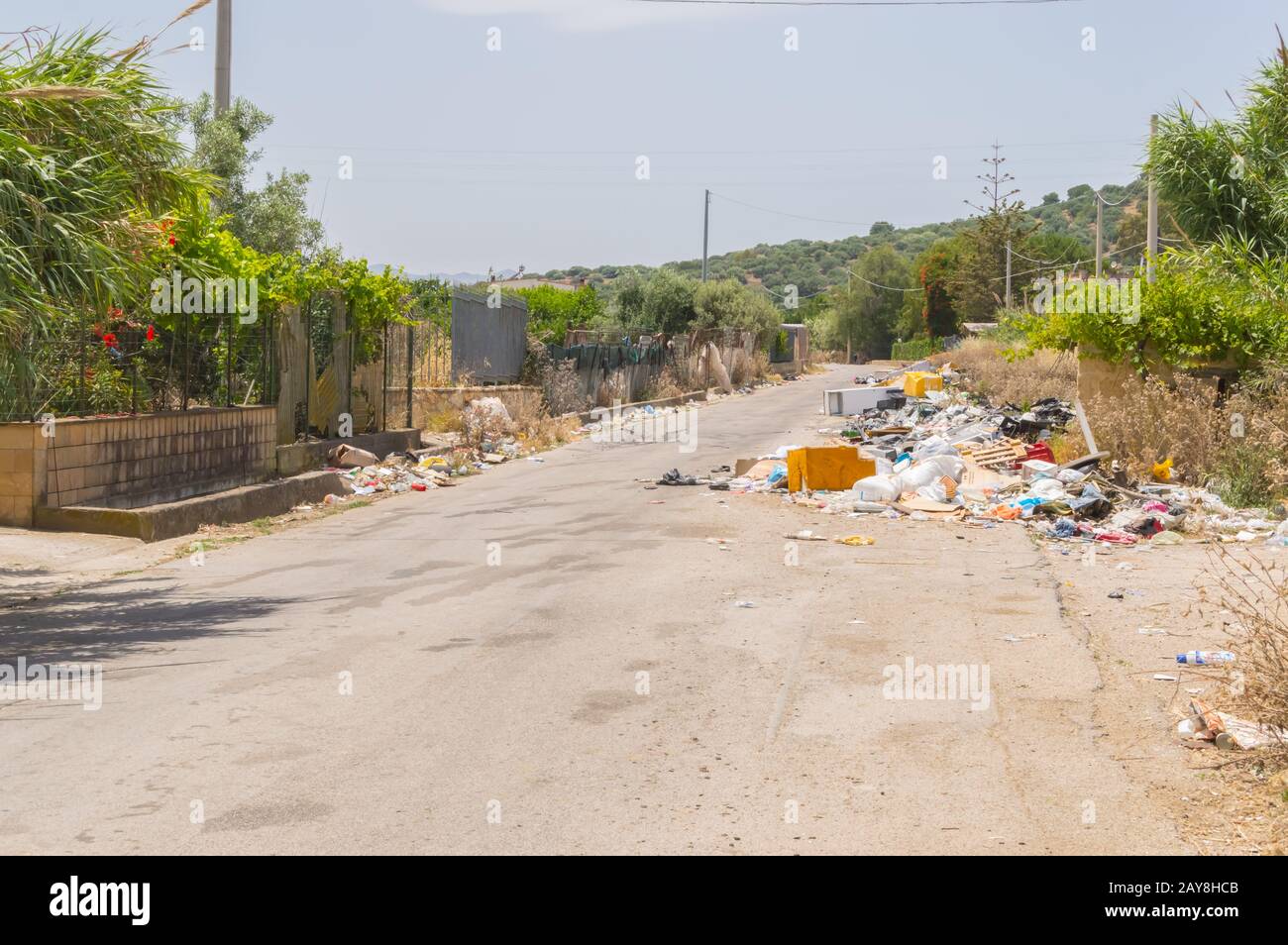 Immondies lungo una strada secondaria in un villaggio Foto Stock