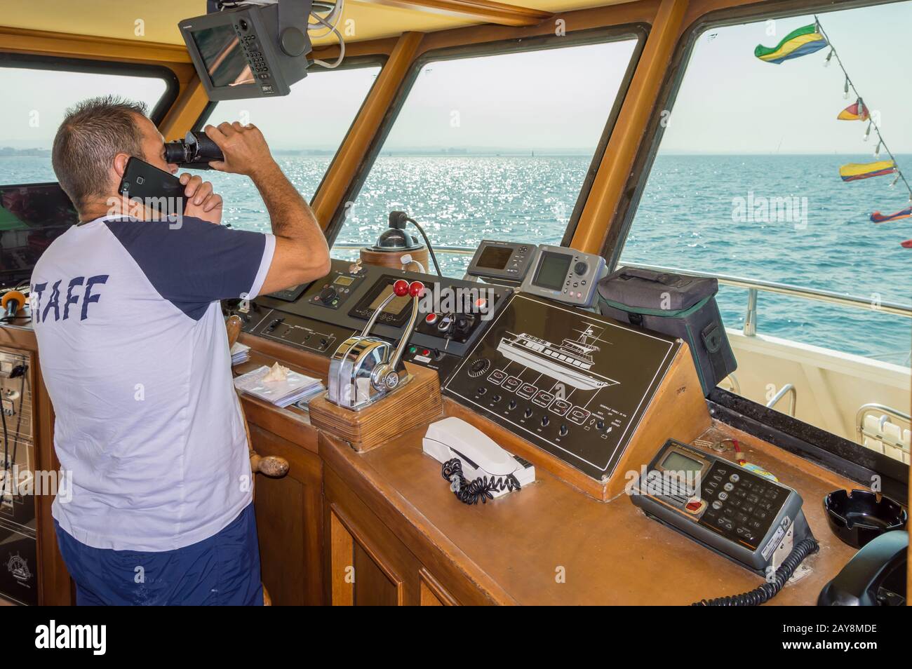 Capitano sul posto di una nave che guarda con binocoli sul mare Adriatico Foto Stock