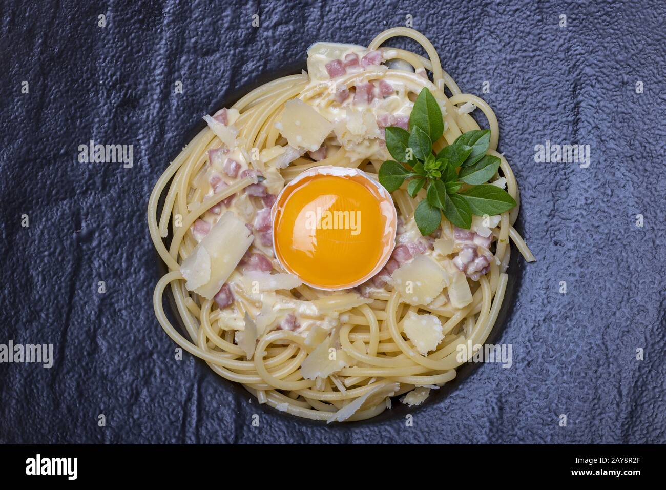 Panoramica degli Spaghetti Carbonara su un piatto nero Foto Stock