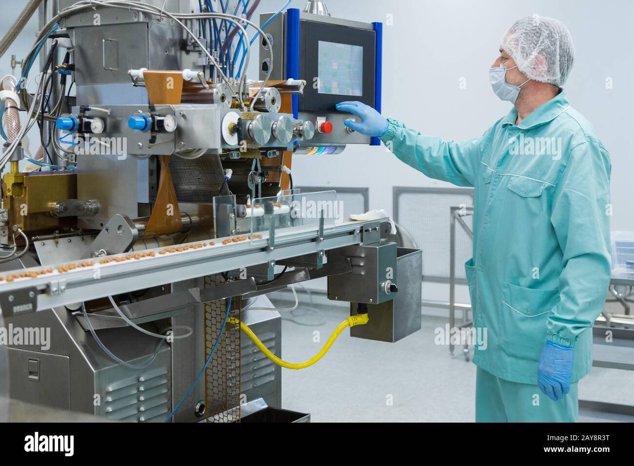 Farmacia industria fabbrica uomo lavoratore in abbigliamento protettivo sterili in condizioni di lavoro Foto Stock