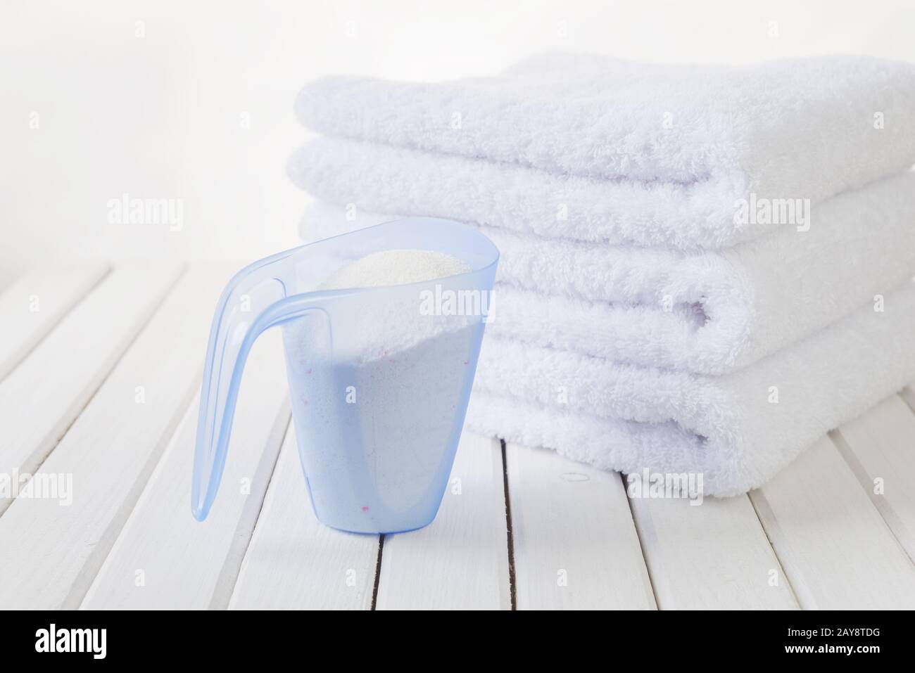 Asciugamani da bagno e detersivo in tazza graduata Foto Stock