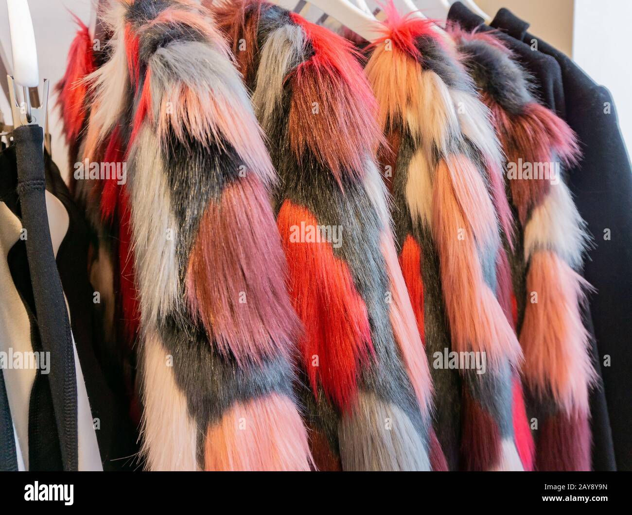 Giacca in pelliccia sintetica per la stagione invernale su un appendiabiti Foto Stock