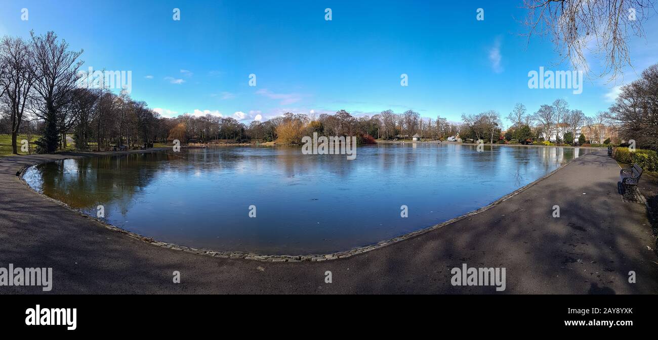 Laghetto semi-congelato al Lease Park di Newcastle, Regno Unito, in una prima primavera soleggiato ma freddo giorno Foto Stock