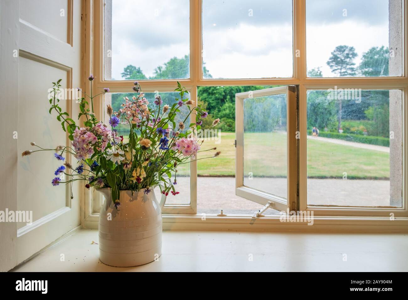 Fiori e finestra vista sui giardini da una casa tradizionale inglese maestoso Foto Stock