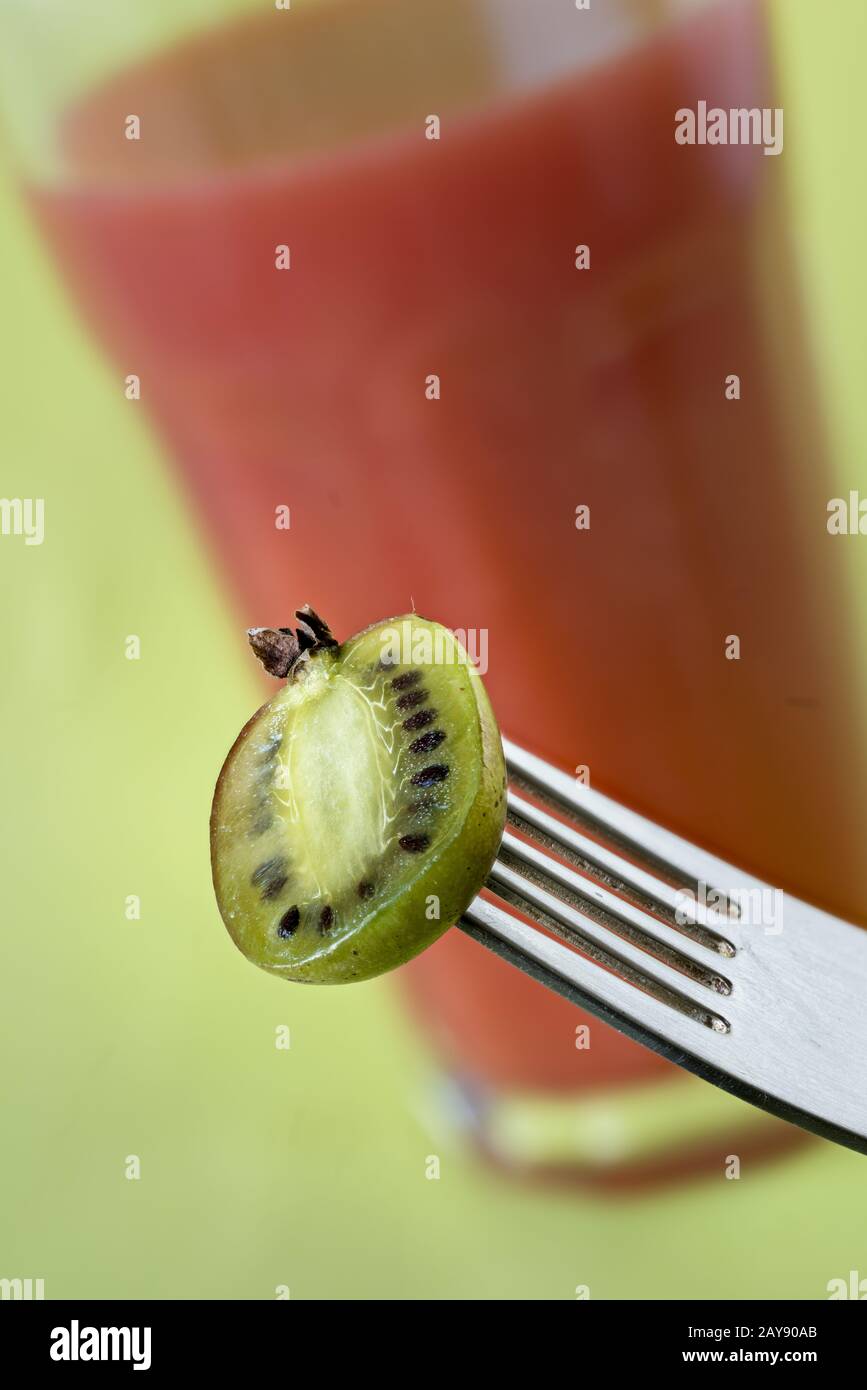 Bacche di kiwi dimezzate e frullato rosso Foto Stock