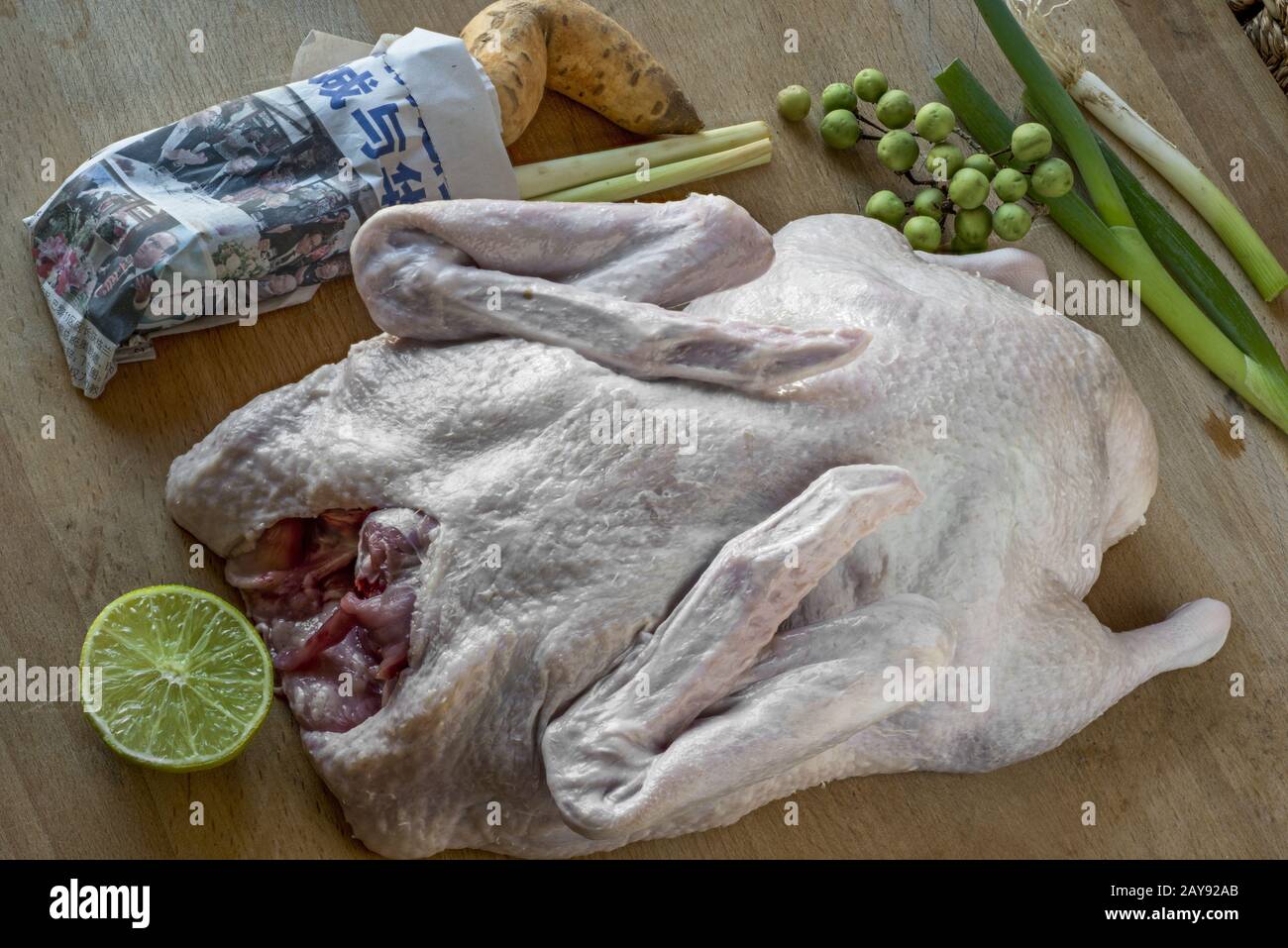 Un'anatra intera con ingredienti per un curry d'anatra Foto Stock