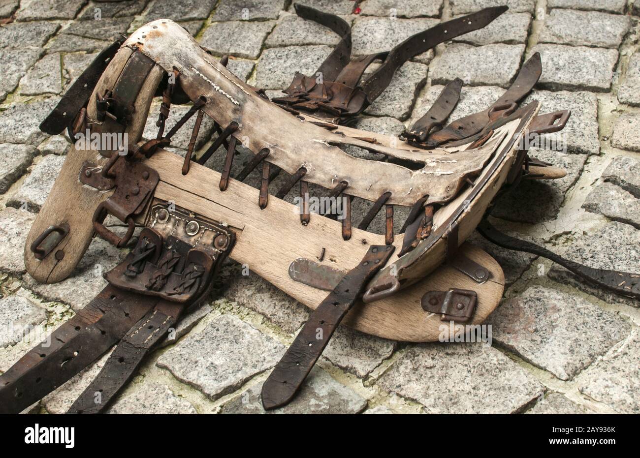 Il vecchio cavallo di vintage in sella in cuoio e legno telaio base tree closeup sul lastricato in pietra della superficie del terreno Foto Stock