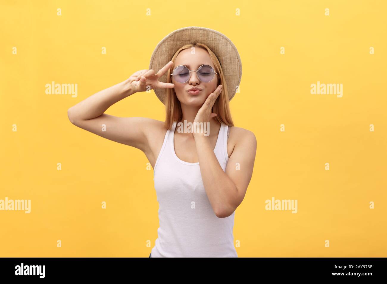 Autoritratto di affascinante ragazza allegra tiro selfie sulla fotocamera anteriore gesturing v-segno simbolo di pace con le dita isolato su y Foto Stock