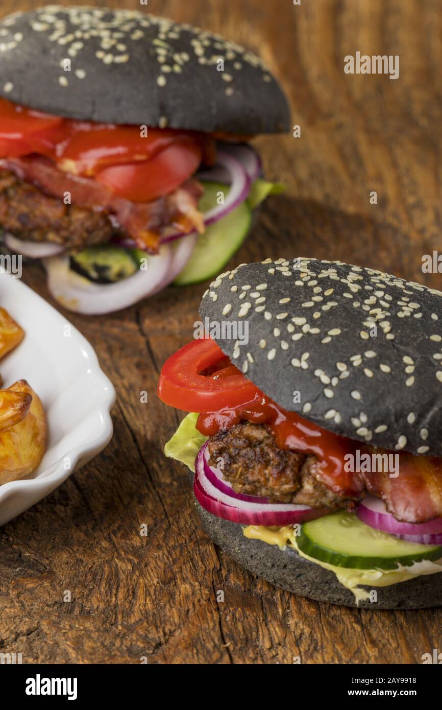 Primo piano degli hamburger neri su legno Foto Stock
