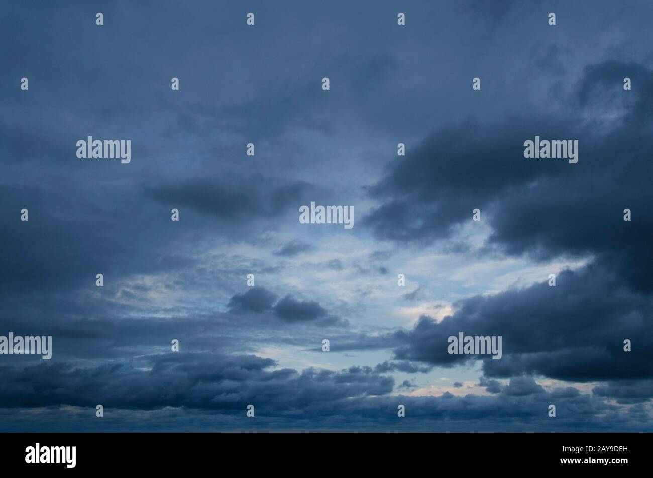 Cloudscape: Sullo sfondo una piccola parte blu chiara, il resto dell'immagine è riempito da nuvole grigio scuro che si estendono attraverso il cielo Foto Stock