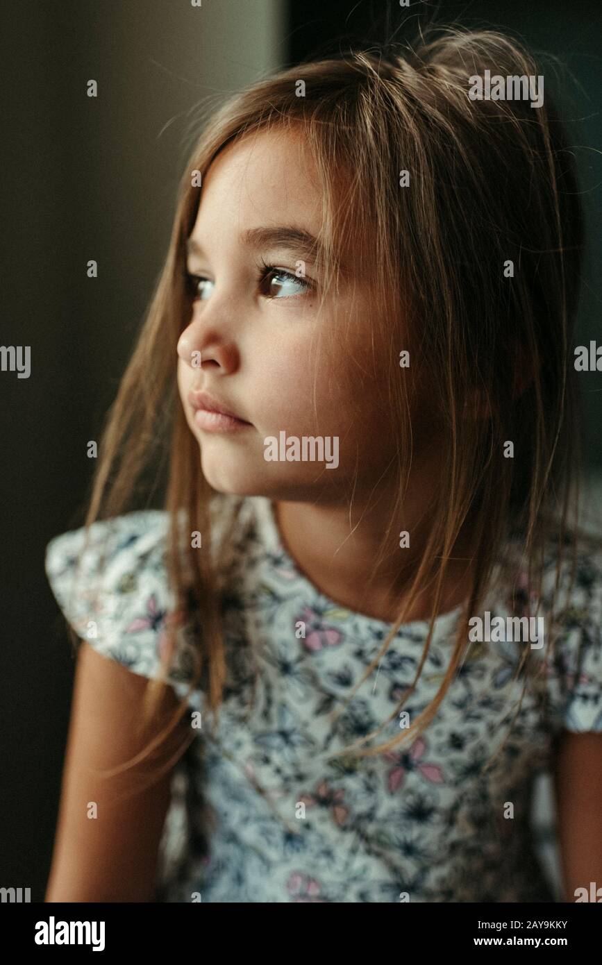 Ragazza che guarda fuori la finestra con capelli caotiche e occhi marroni a Buda Texas Foto Stock