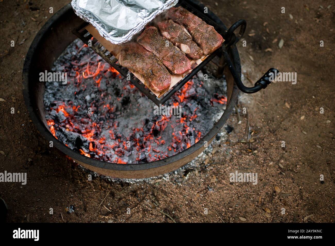 Grigliate bistecca su un fuoco con calici caldi in Moody Texas Foto Stock