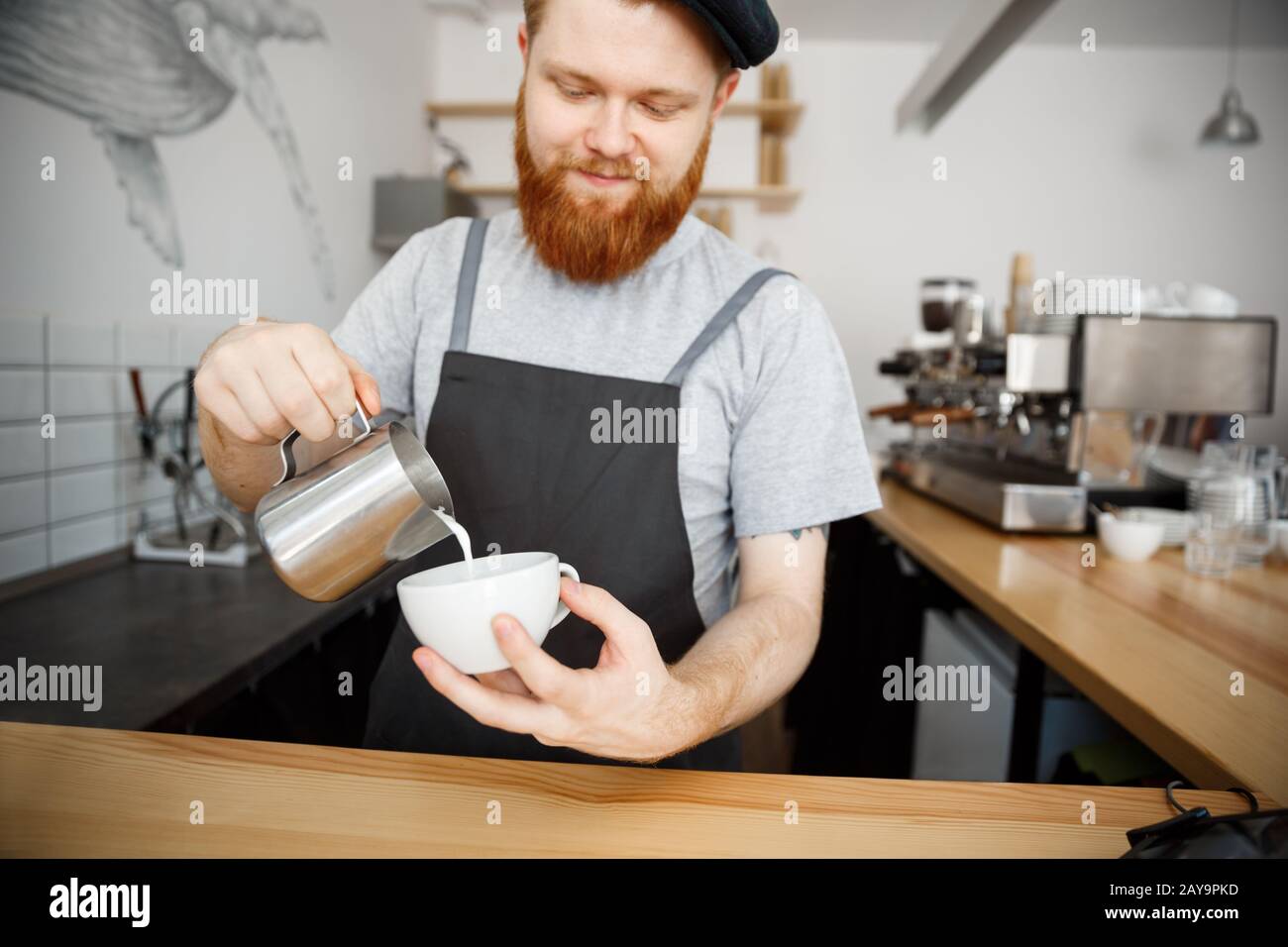 Caffè il concetto di Business - bel uomo barbuto in grembiule fare il caffè mentre in piedi presso il cafe Foto Stock