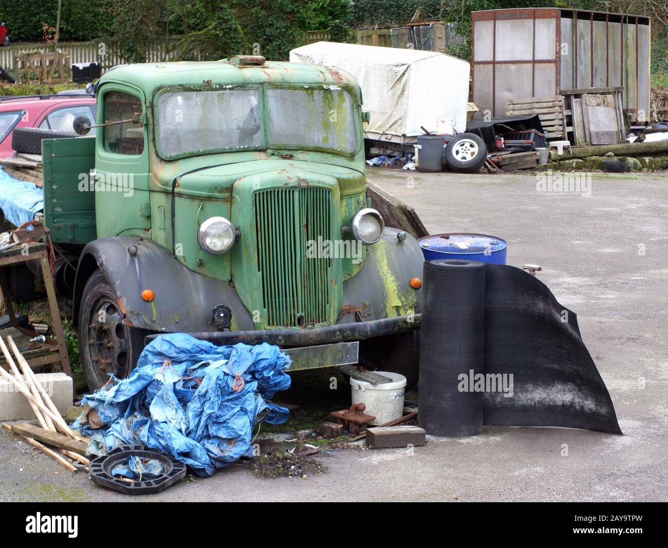 un vecchio camion verde ruggine con rottami di legno e metallo in un cantiere rurale Foto Stock