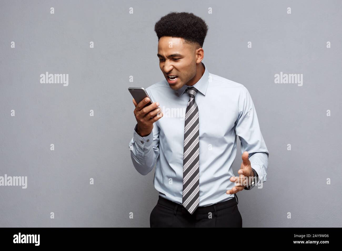 Il concetto di business - stressante african american businessman gridando e urlando sul telefono cellulare. Foto Stock