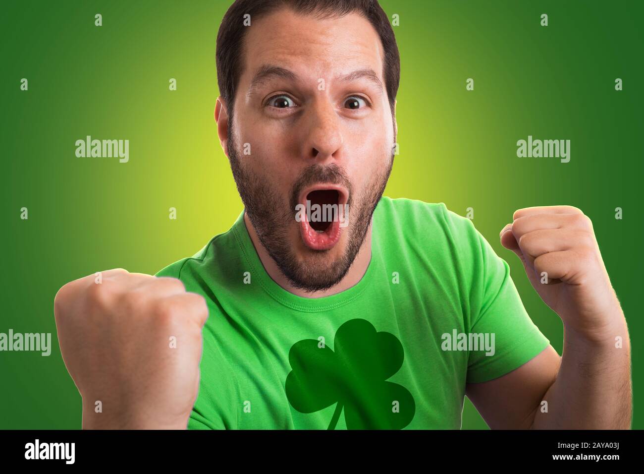 Uomo che indossa il verde t-shirt con shamrock stampati su di essa celebra la festa di San Patrizio. Foto Stock
