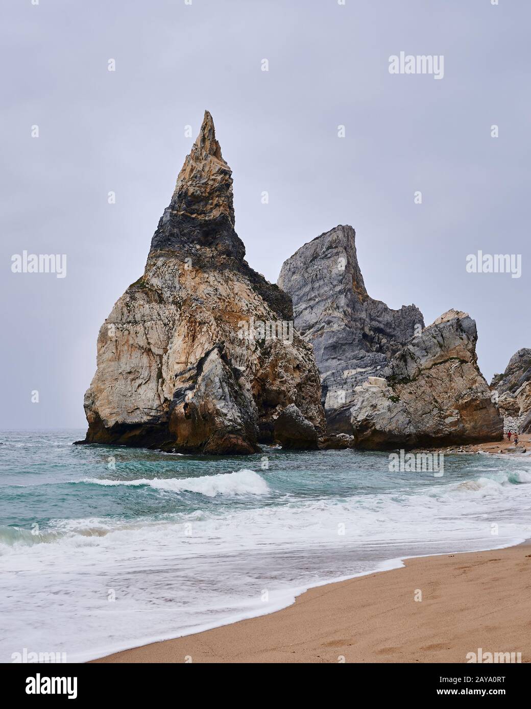 Roccia gigante alla fine della spiaggia in giornata torbida Foto Stock