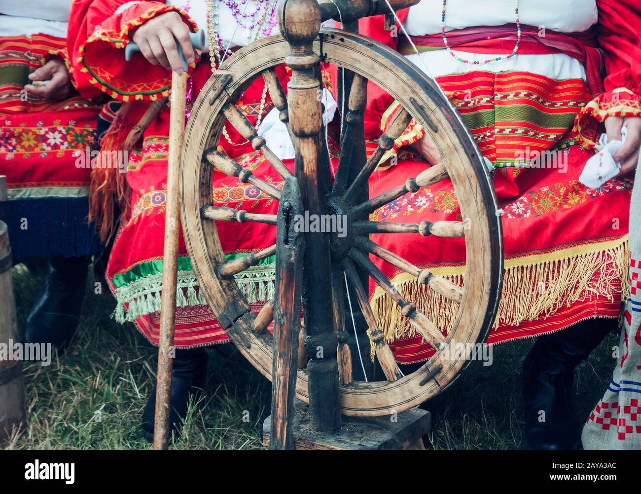 In legno antico ruote di filatura e di una donna in costume nazionale. Foto Stock