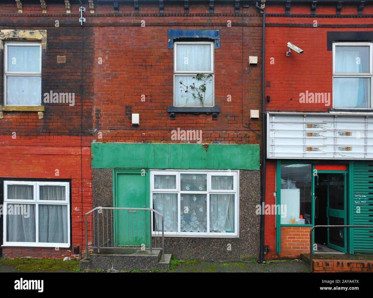corri giù case a schiera su una strada a leeds con pareti dipinte colorate e decadenti Foto Stock