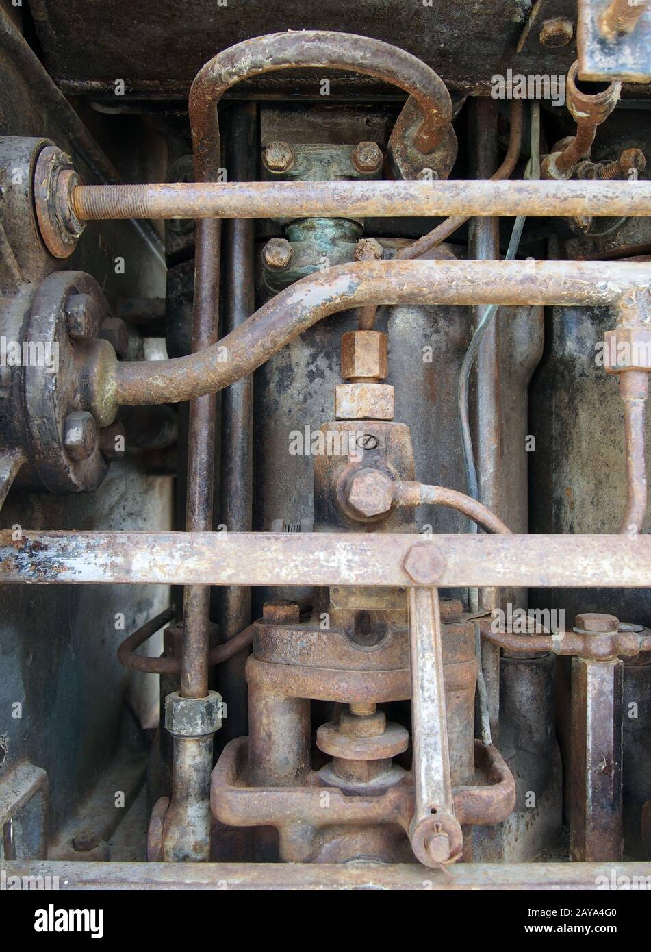 primo piano di un grande vecchio motore diesel marino abbandonato con tubi arrugginiti, cilindri e bulloni Foto Stock