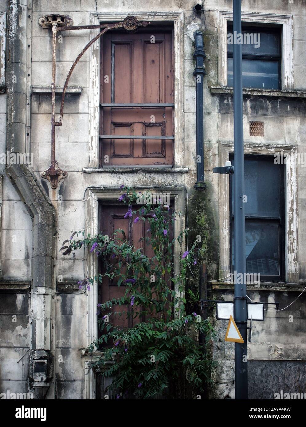 facciata di un derelict che crolla proprietà commerciale abbandonata in un centro della città Foto Stock