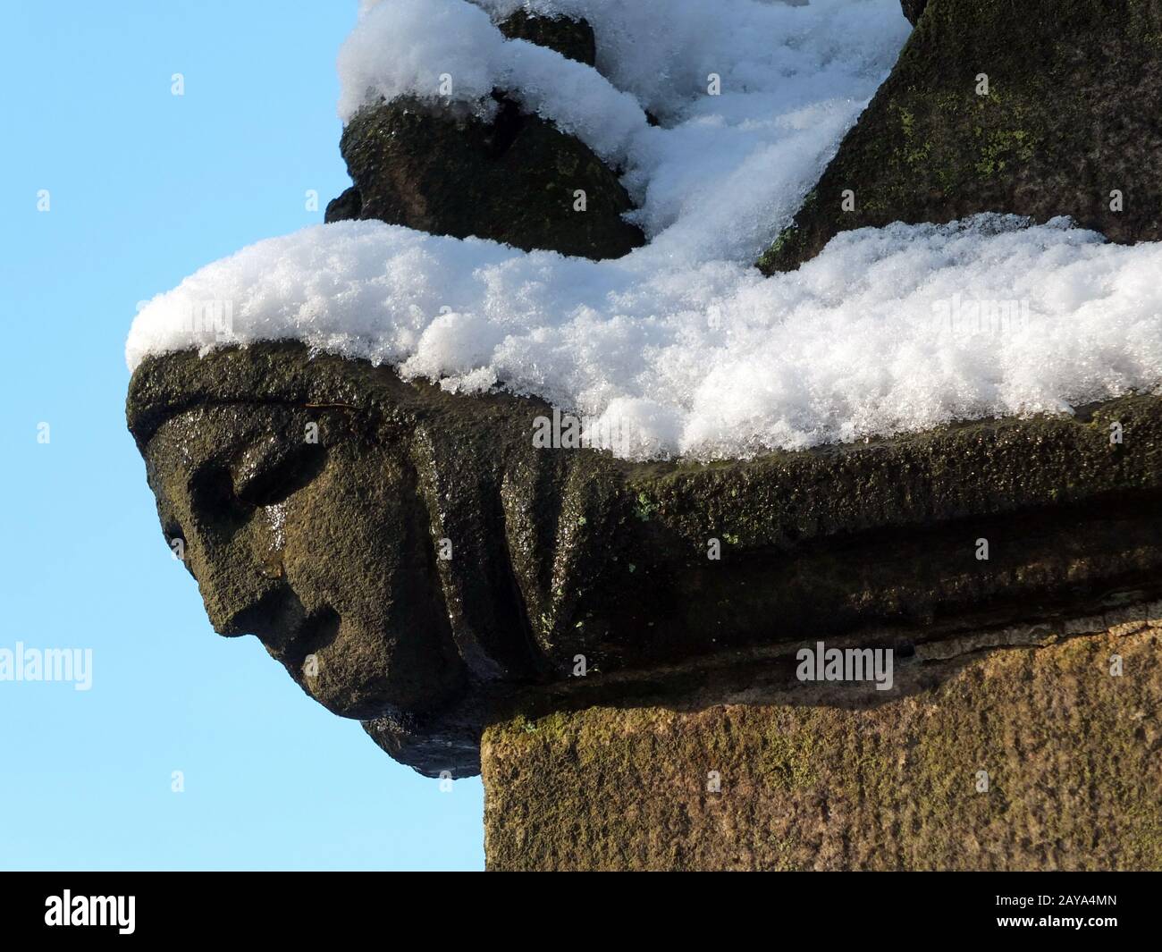 primo piano dell'intaglio di una faccia womans in profilo onananticamente rovinato chiesa medievale con neve Foto Stock