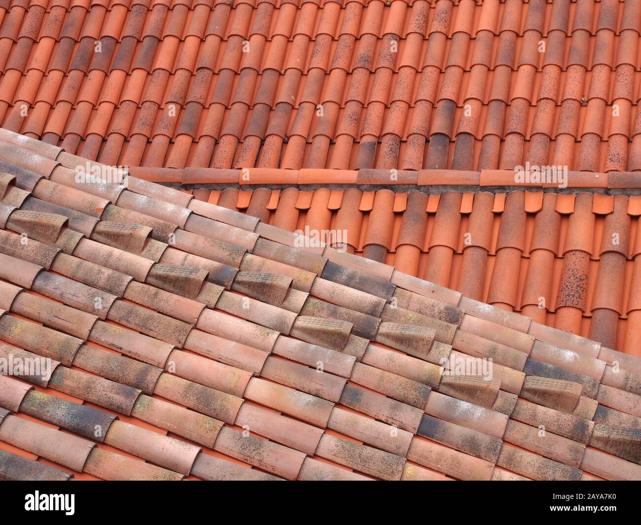 vista a cornice di vecchi e nuovi tetti tradizionali in terracotta rossa con tegole curve sovrapposte a linee sovrapposte Foto Stock