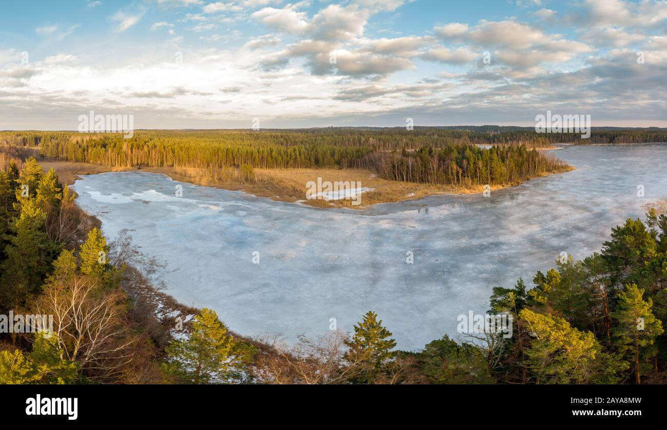 Terra e un lago ghiacciato nella regione Ostergotland della Svezia orientale Foto Stock